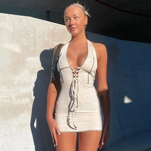 Détail de la robe mini dos nu beige montrant la texture en maille côtelée au soleil