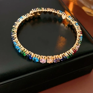 Close-up of rainbow cubic zirconia tennis bracelet with gold-plated four-prong settings