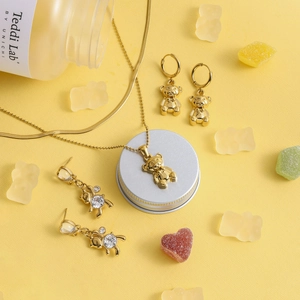 Golden bear jewelry set featuring pendant necklace and earrings on yellow candy backdrop