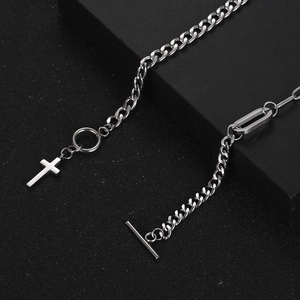 Silver cross pendant necklace with OT clasp buckle on a black textured background