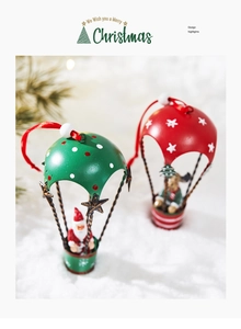 Christmas hot air balloon ornaments with Santa and reindeer on snowy pine background