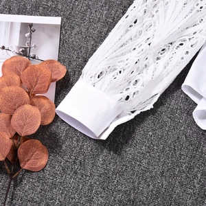 Close-up of intricate white lace crochet cuffs on a stylish long-sleeved shirt for women