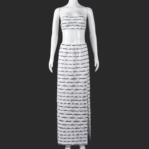 Close-up of black and white striped jacquard fabric with fringe details on a skirt set