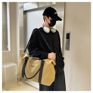 Khaki large capacity travel duffel bag with shoulder strap shown in an elevator setting
