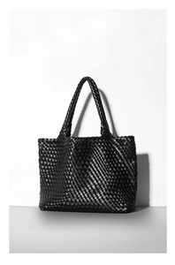 Detailed view of black woven tote bag with intricate texture and sturdy handle