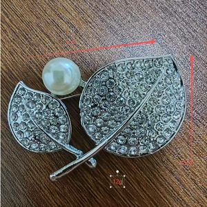 Detail view of leaf brooch showing dimensions 5cm by 3.5cm with rhinestones and pearl