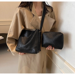 Close-up of black woven leather tote bag set with matching inner pouch on model
