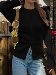 Détail d'un cardigan noir à manches longues avec boutons et jean bleu décontracté