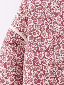 Close-up of pink floral quilted jacket featuring white flower prints and stitch details