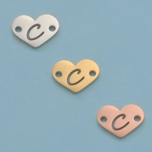 Detail of 12mm heart shaped mirror steel charms in silver gold and rose gold with letter C