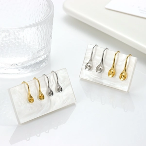 S925 sterling silver spoon shaped ear hooks in gold and silver on marble display