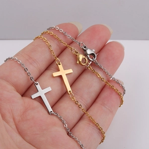 Detail shot of gold and silver stainless steel cross bracelets on hand with lobster clasp