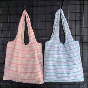 Détail de sacs cabas rayés en toile avec texture seersucker unique en deux palettes