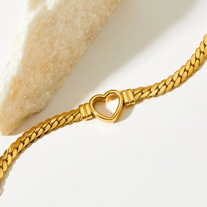 Gold hollow heart Cuban chain bracelet on a white surface with natural crystal stone