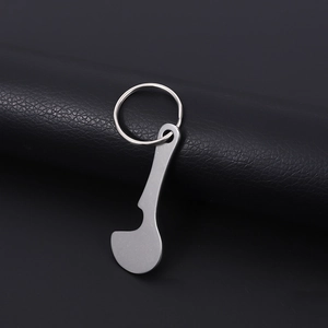 Polished silver stainless steel shopping cart token keychain on a black leather background