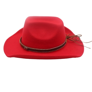 Detail of red cowboy hat featuring a brown leather braided band and tassel accents