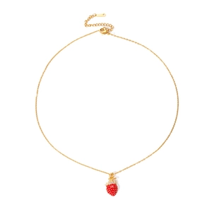 Détail d'un collier pendentif fraise doré avec émail rouge et feuilles en cristal brillant