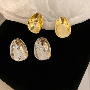 Irregular geometric metal stud earrings in gold and silver with liquid textured finish