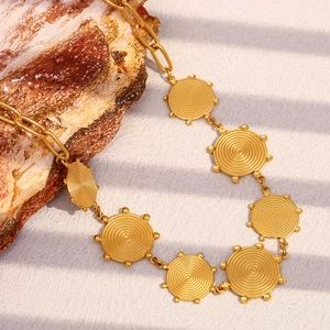 Detail of 18K gold-plated stainless steel necklace with engraved spiral sun disk pendant