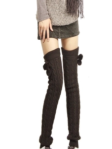 Close-up of cable knit leg warmers in dark coffee with side pom-poms and ribbed texture