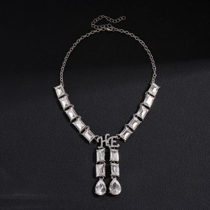 Close-up of sparkling geometric drop pendant necklace with rhinestone square links