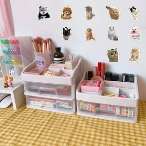 White tiered desktop organizers on a yellow plaid tablecloth with assorted stationery accessories