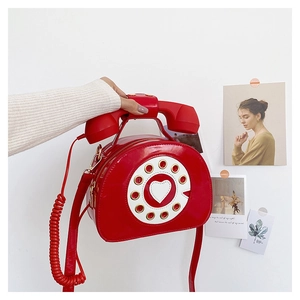Macro detail of red patent leather retro telephone bag with dial design and handset handle