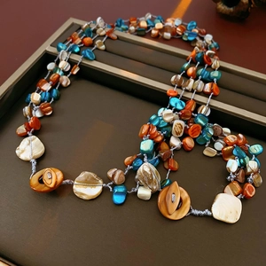 Close-up of bohemian multi-layer necklace with colorful shell beads on a dark tray