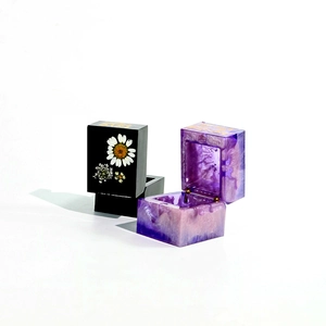 Macro view of square resin jewelry boxes featuring floral patterns and LOVE lettering