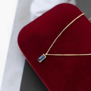 Vintage stainless steel necklace featuring a rectangular blue zircon pendant on red velvet