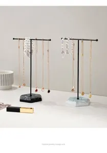 Detail view of T-bar jewelry display stands with hexagonal marble bases in black and white