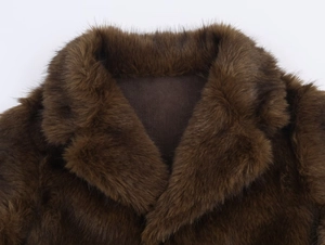 Détail d'un col en fausse fourrure marron foncé montrant la texture douce de la veste