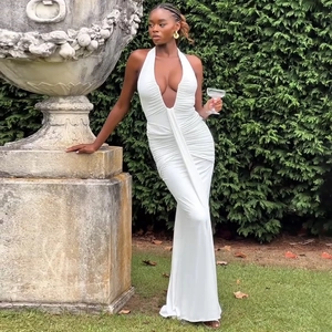 Détail d'une robe longue blanche à col licou avec un design plissé et une coupe ajustée