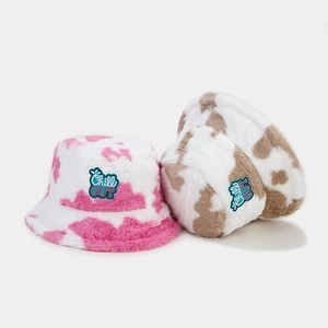 Winter plush bucket hats with pink and brown cow print featuring Chill OUT embroidery