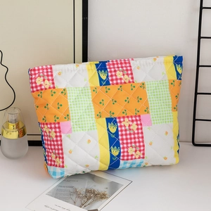 Macro detail of quilted cotton makeup bag with floral patterns and colorful patchwork