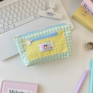 Detail of checkered pencil case with yellow pocket and happy vibe embroidery