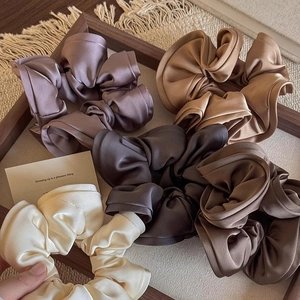 Set di 5 elastici vintage in raso nei toni crema e marrone su vassoio di legno