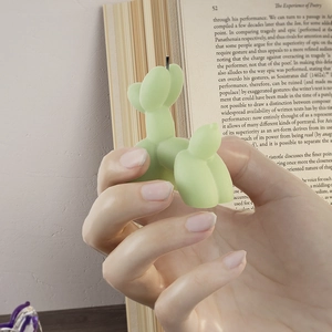 Detailed view of a light green balloon dog scented candle with a matte finish texture
