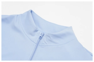 Dettaglio top yoga celeste con collo alto, zip in tinta e cuciture di alta qualità