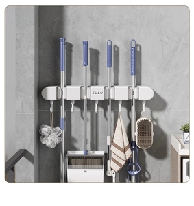 Detail of suction cup wall mount mop holder with gravity slots and hooks on tiles