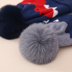 Vue détaillée du tricot doux et du pompon en fausse fourrure sur le bonnet d'hiver enfant