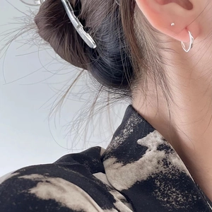 Minimalist silver pleated stud earrings and metal hair clip set on a female model
