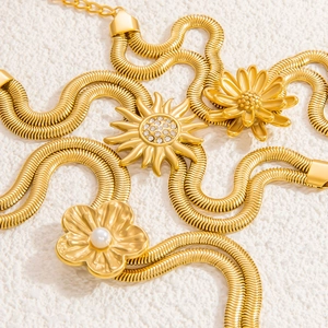 Zweilagige 18K vergoldete Schlangenkette mit Perlenanhänger und Blumen auf weißem Sand