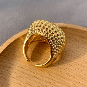 Detailansicht eines vergoldeten klobigen offenen Rings mit einzigartiger Perlentextur