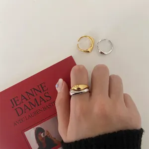 Minimalist liquid-style adjustable rings in gold and silver finish on model hands