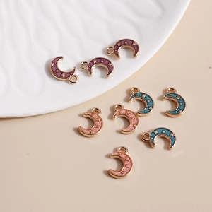 Macro view of purple and blue enamel crescent moon charms with gold alloy finish