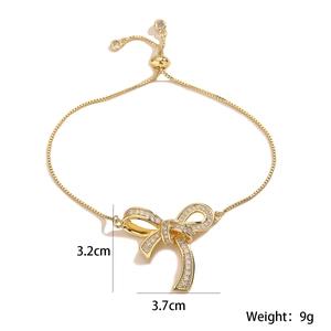 Detail showing bow pendant dimensions 3.7cm by 3.2cm and weight 9g on golden bracelet
