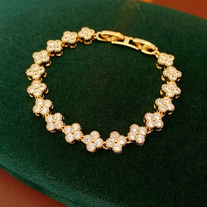 Bracelet trèfle plaqué or avec zircons sertis sur un fond de velours vert