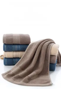 Detail showing plush cotton towels with elegant gold stripe embroidery and rich looped texture
