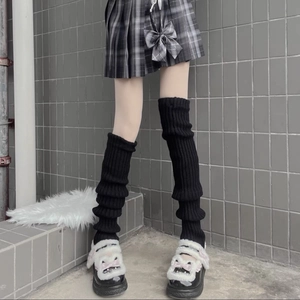 Detail of black knitted leg warmers showing slouchy texture with platform shoes